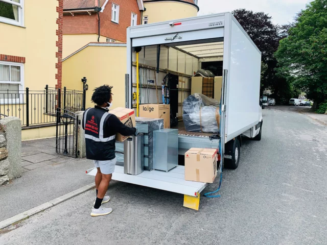 Chargement d’un camion à hayon dans la rue : cartons et mobilier sur la plateforme relevée
